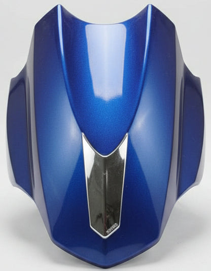 Blue motorcycle seat with a silver emblem on a red surface