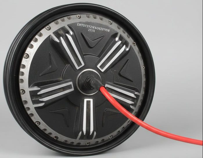 Close-up of a motor with a red cable attached, on a light-colored floor.