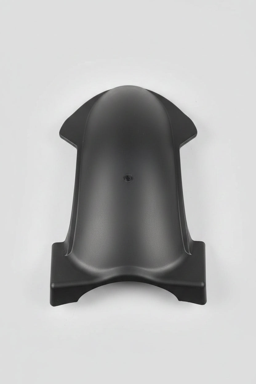 Black plastic object on a red surface with various items in the background