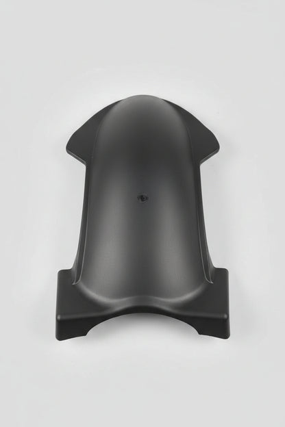 Black plastic object on a red surface with various items in the background