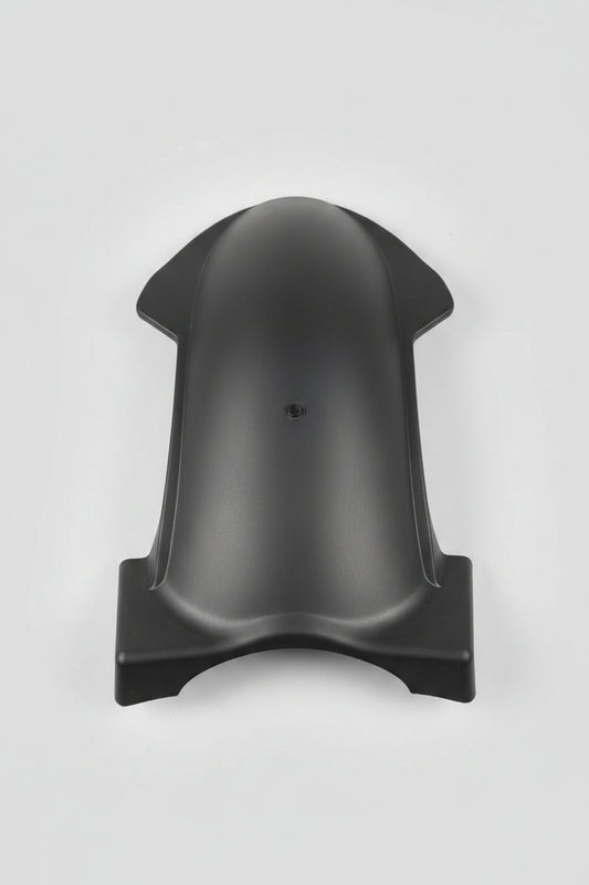 Black plastic object on a red surface with various items in the background