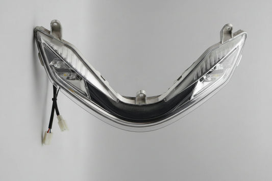 Car headlight assembly with plastic cover removed, showing internal components.