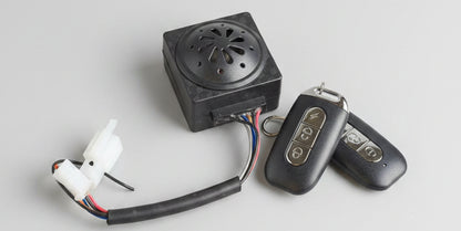 Vintage-style fire starter with sparkplug and remote control on a red surface