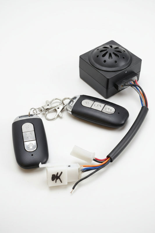 Car key fob, remote control, and electronic device on a red surface