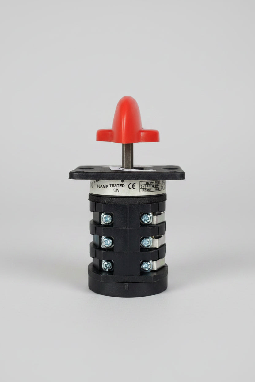 A black plastic automotive light switch module with a red plastic top cover and a gold-colored terminal ring, photographed on a textured red background.