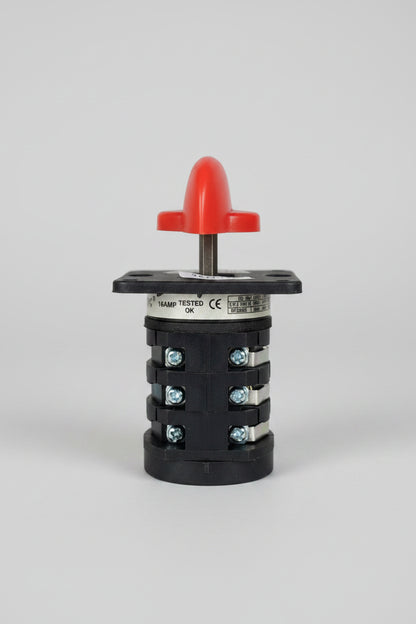 A black plastic automotive light switch module with a red plastic top cover and a gold-colored terminal ring, photographed on a textured red background.