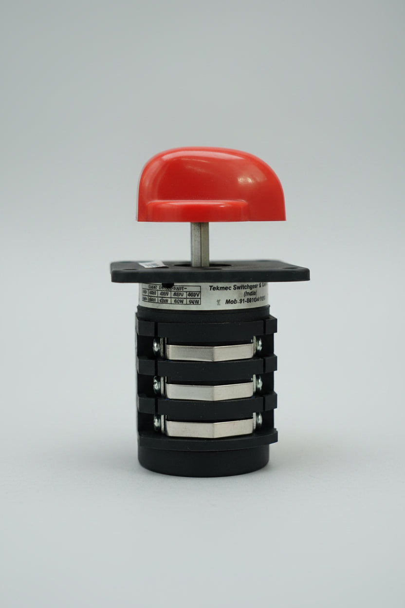A small industrial electrical component, specifically a red and black rotary switch or contactor module, photographed against a textured red background.