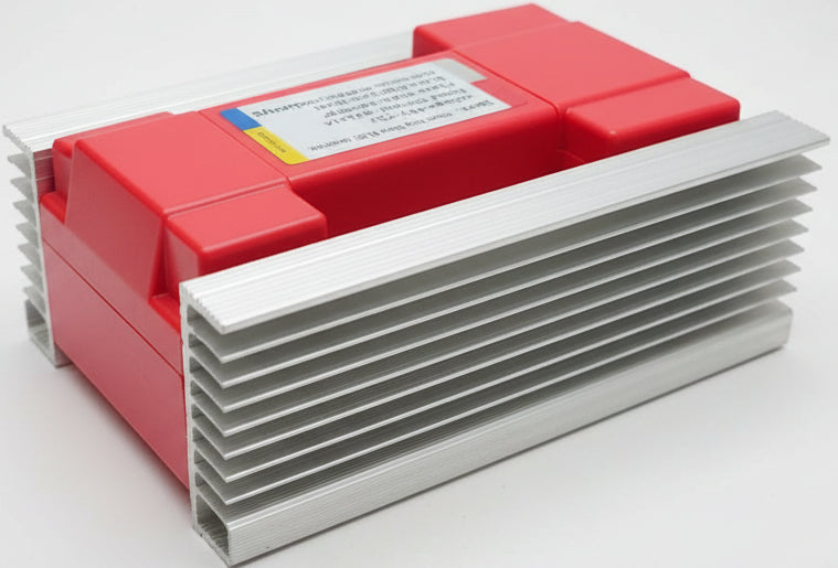 A stack of silver aluminum heat sinks with a red plastic heatsink block on top, photographed on a desk with a keyboard and mouse in the background.